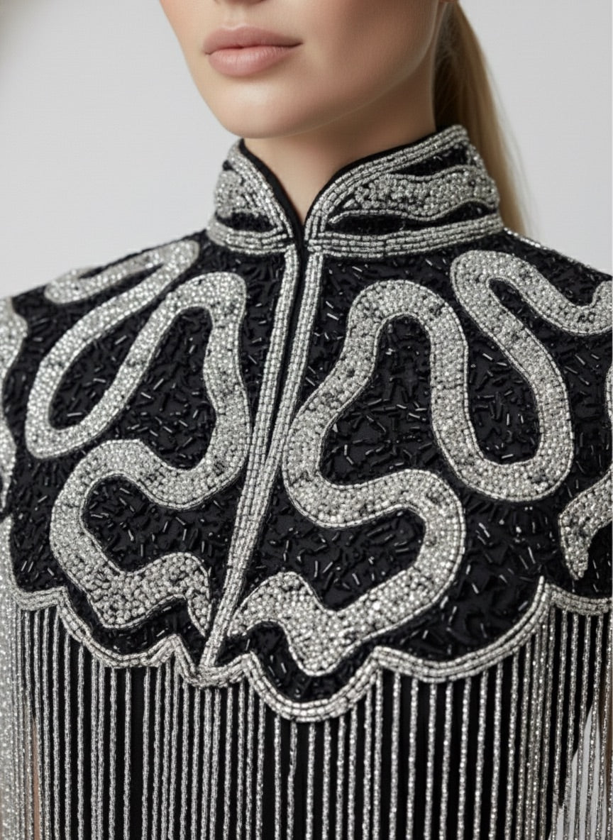 L'Jai Amor Noir Sovereign Cape displayed on a mannequin, featuring elegant black fabric and intricate detailing.