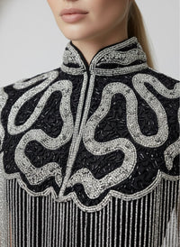 L'Jai Amor Noir Sovereign Cape displayed on a mannequin, featuring elegant black fabric and intricate detailing.