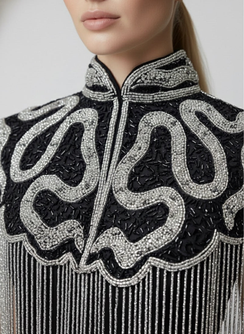 L'Jai Amor Noir Sovereign Cape displayed on a mannequin, featuring elegant black fabric and intricate detailing.
