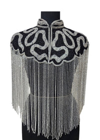 L'Jai Amor Noir Sovereign Cape draped elegantly, showcasing luxurious black fabric with intricate detailing and regal style.