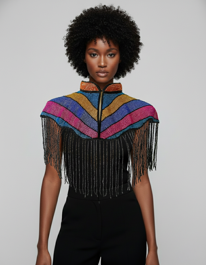 L'Jai Amor Solidarity Cape draped over shoulders, vibrant fabric with intricate patterns, cultural and stylish accessory.