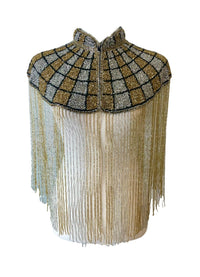 L'Jai Amor Gilded Mosaic Cape displayed on a mannequin with intricate gold and mosaic patterns, elegant and stylish.