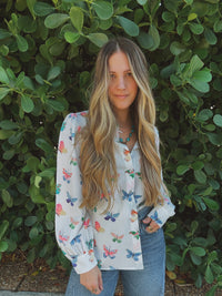 Lil Bee's Bohemian butterfly button-up blouse featuring eye-catching face and butterfly designs in a stylish apparel image.