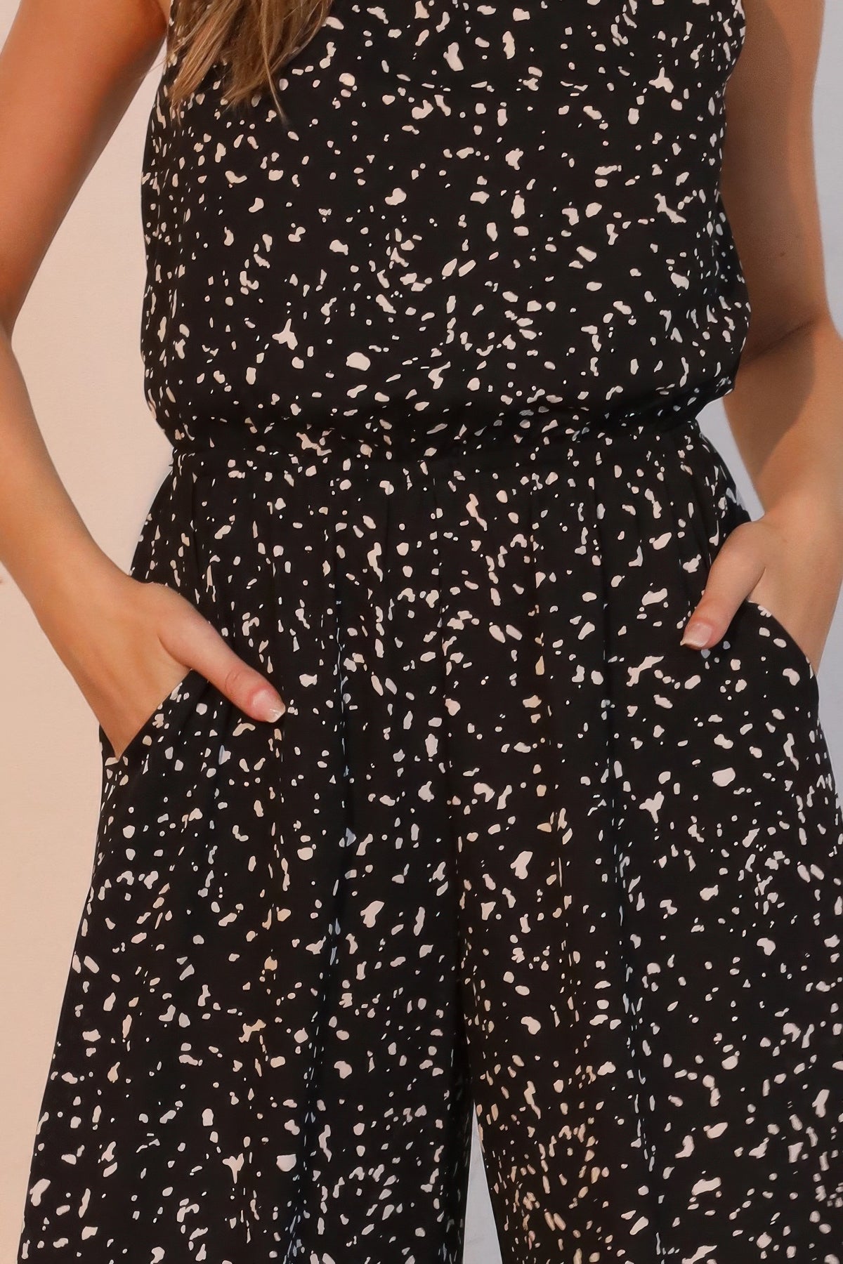 LORNEA Ink Spot sleeveless bubble jumpsuit with relaxed fit and adjustable straps, featured on a model outdoors.