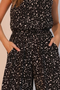 LORNEA Ink Spot sleeveless bubble jumpsuit with relaxed fit and adjustable straps, featured on a model outdoors.