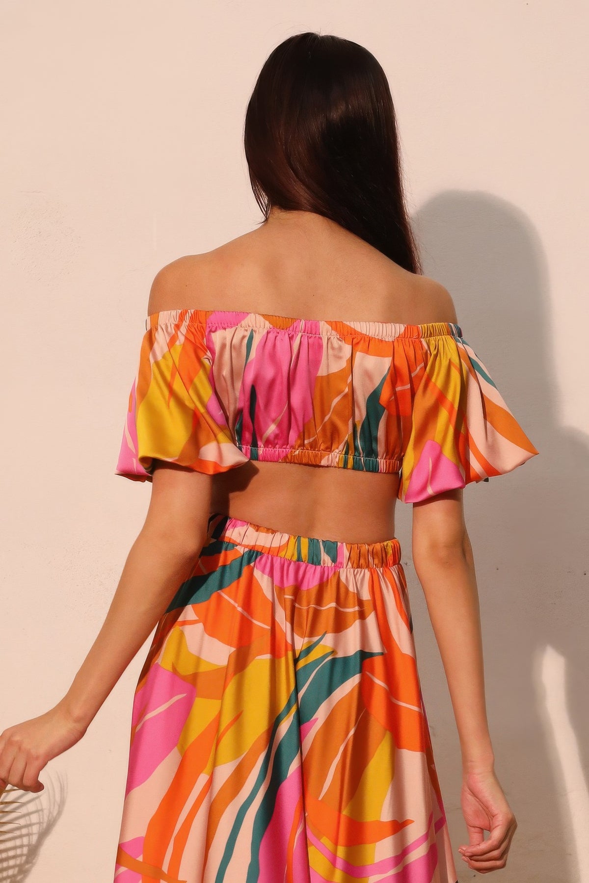 LORNEA Isla Tropical satin bubble sleeve crop top in vibrant tropical print, featuring puffed sleeves and a fitted design.