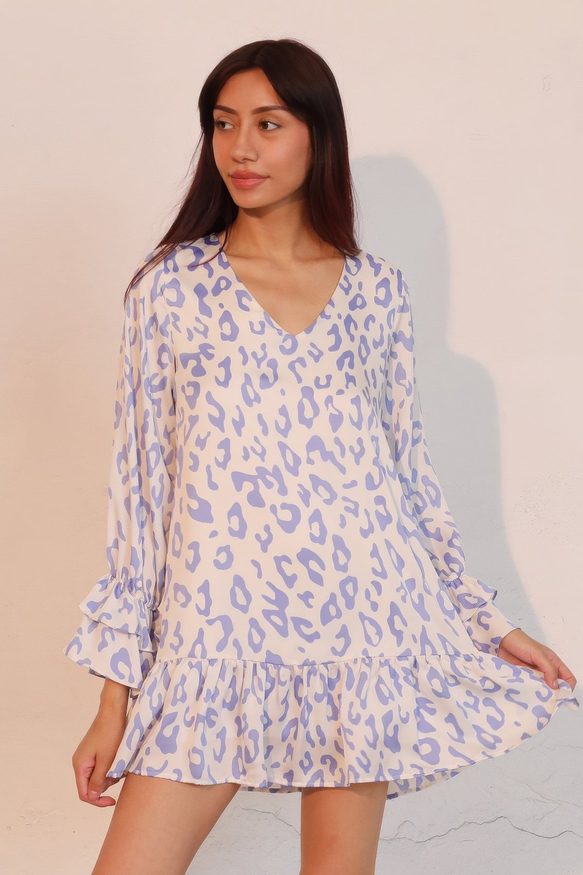LORNEA simple leopard dress with ruffle cuffs hanging on a hanger, showcasing its stylish pattern and elegant design.