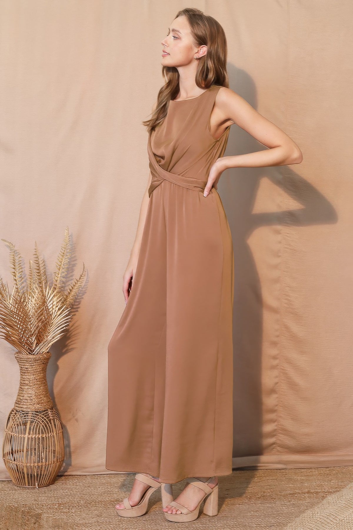 LORNEA washed poly silk twist front jumpsuit displayed on a hanger, featuring a stylish front twist design and smooth fabric.