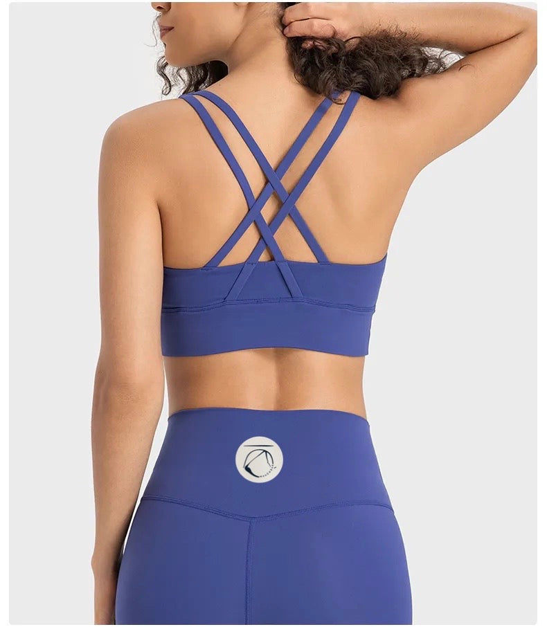Manō Wear Pele sports bra in black with racerback design, shown on a mannequin for activewear and workout use.