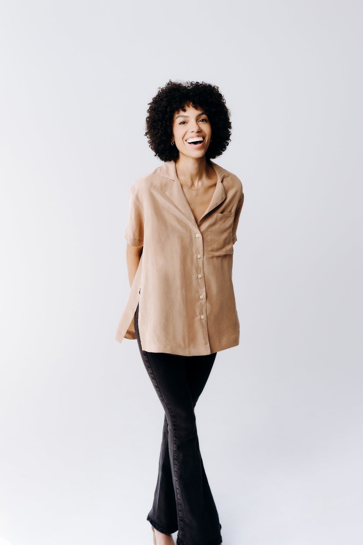 Margo Paige washable silk button-down shirt displayed on a hanger, showcasing smooth, shiny fabric and classic collar style.