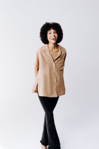 Margo Paige washable silk button-down shirt displayed on a hanger, showcasing smooth, shiny fabric and classic collar style.