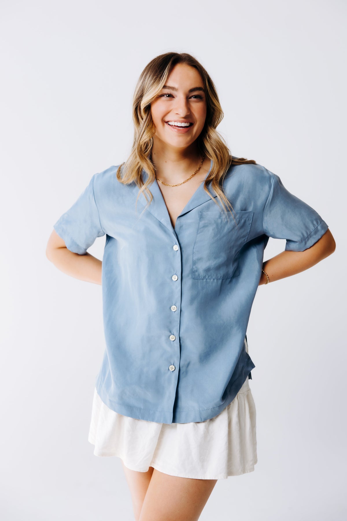 Margo Paige washable silk button-down shirt displayed on a hanger, showcasing smooth, shiny fabric and classic collar design.