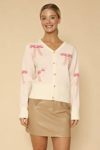Miss Sparkling cropped knit bow cardigan showing a close-up of the textured knit fabric and bow detail on the front.