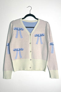 Miss Sparkling cropped knit bow cardigan featuring a soft knit fabric and a charming bow detail at the front.