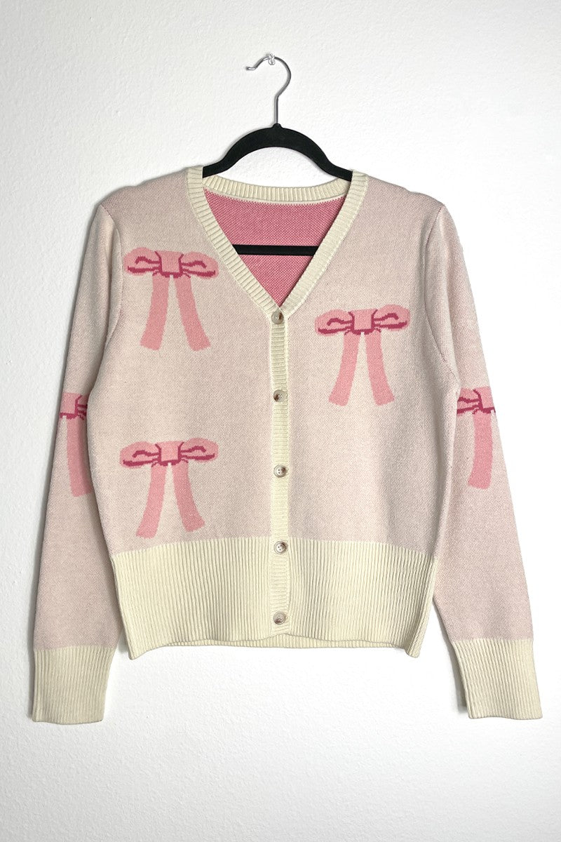 Miss Sparkling cropped knit bow cardigan with a fitted design, featuring a bow detail and long sleeves in soft, textured yarn.