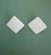 White Modafleur The Square handbag with clean, structured design and top handle, showcased on a neutral background.