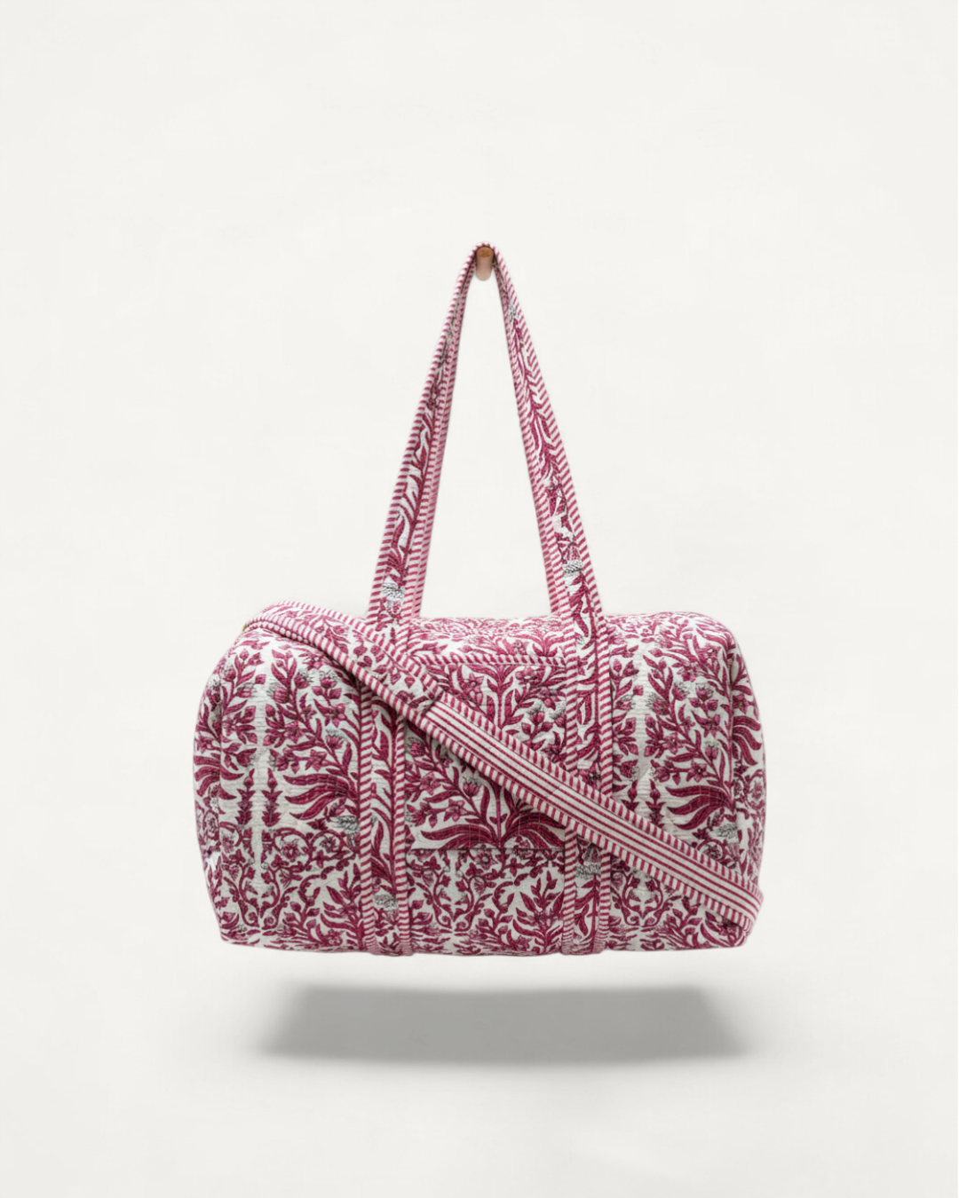 Pink floral quilted overnight duffle bag with handles and zipper closure, stylish and spacious for travel and accessories.