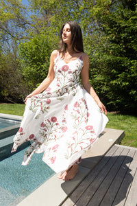 Red vine cross-back maxi dress from nibimtk.com, flowing fabric with a stylish back design and vibrant floral pattern.