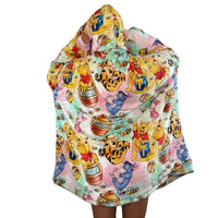 Olm Collectibles Winnie the Pooh & Friends wearable blanket hoodie for kids and adults, featuring soft, cozy fabric with character print.