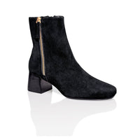 Black suede Arina dress ankle bootie with block heel by Joan Oloff Shoes, featuring a sleek design and stylish silhouette.
