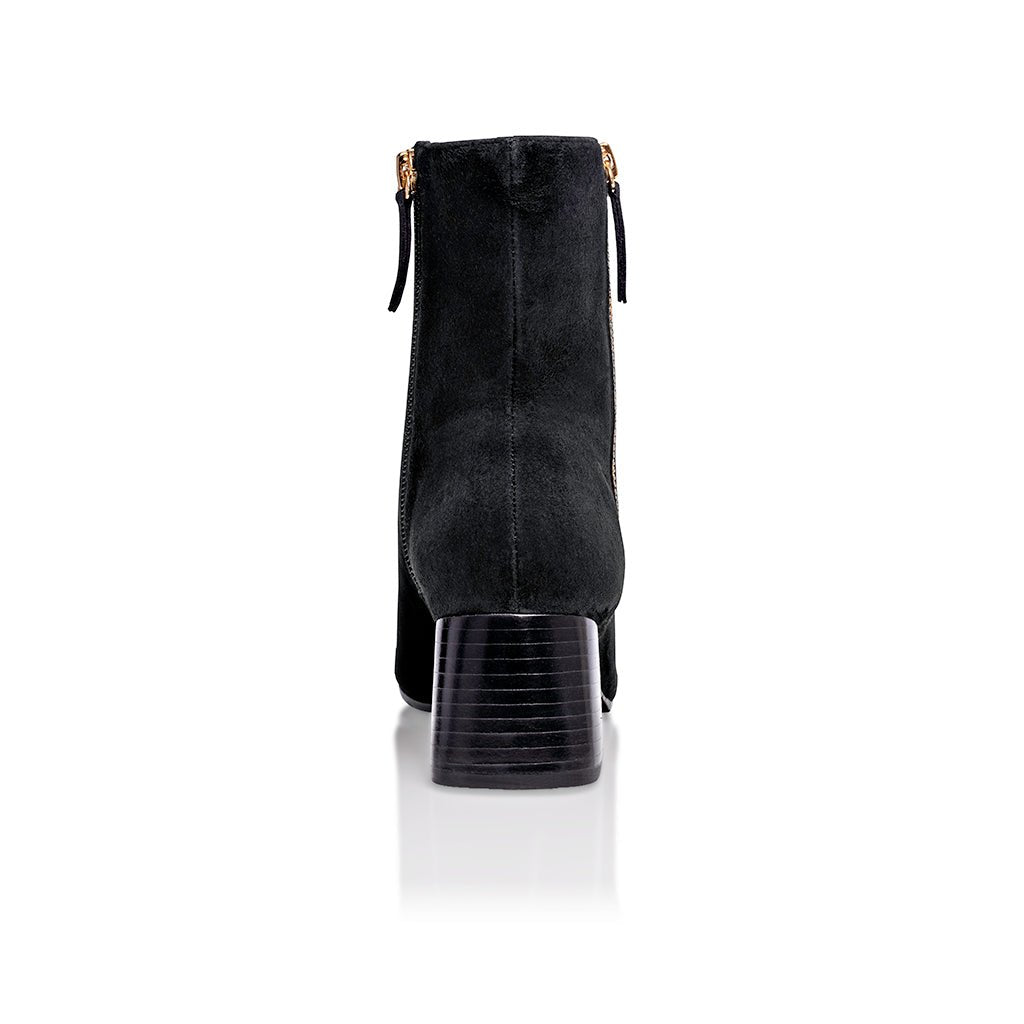 Black suede Arina Dress ankle bootie with a block heel from Joan Oloff Shoes, featuring a sleek design and stylish silhouette.
