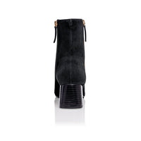 Black suede Arina Dress ankle bootie with a block heel from Joan Oloff Shoes, featuring a sleek design and stylish silhouette.