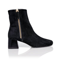 Black suede Arina ankle bootie with a block heel from Joan Oloff Shoes, showcasing the stylish design and textured material.