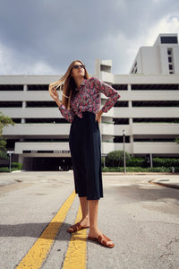 Floral silky blouse by profile-nyc with a flowy fit and vibrant flower print, displayed on a hanger.