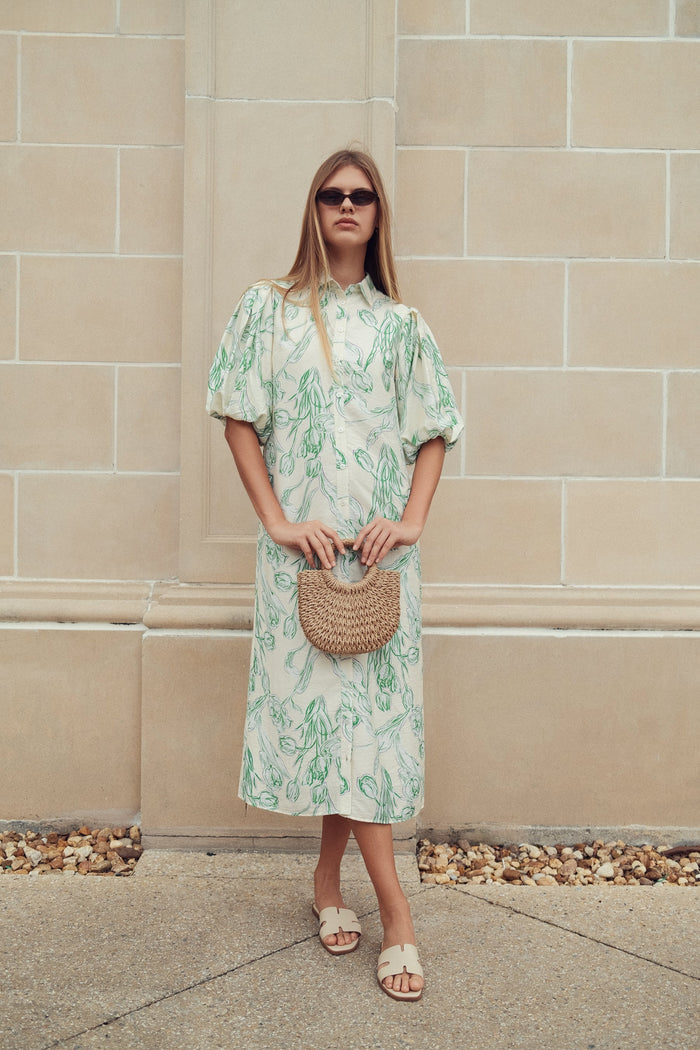 Floral linen dress by profile-nyc displayed on a hanger with a colorful floral pattern and lightweight fabric.