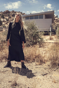 Black bell sleeve dress by Profile NYC featuring a stylish, flowy silhouette and elegant bell-shaped sleeves.