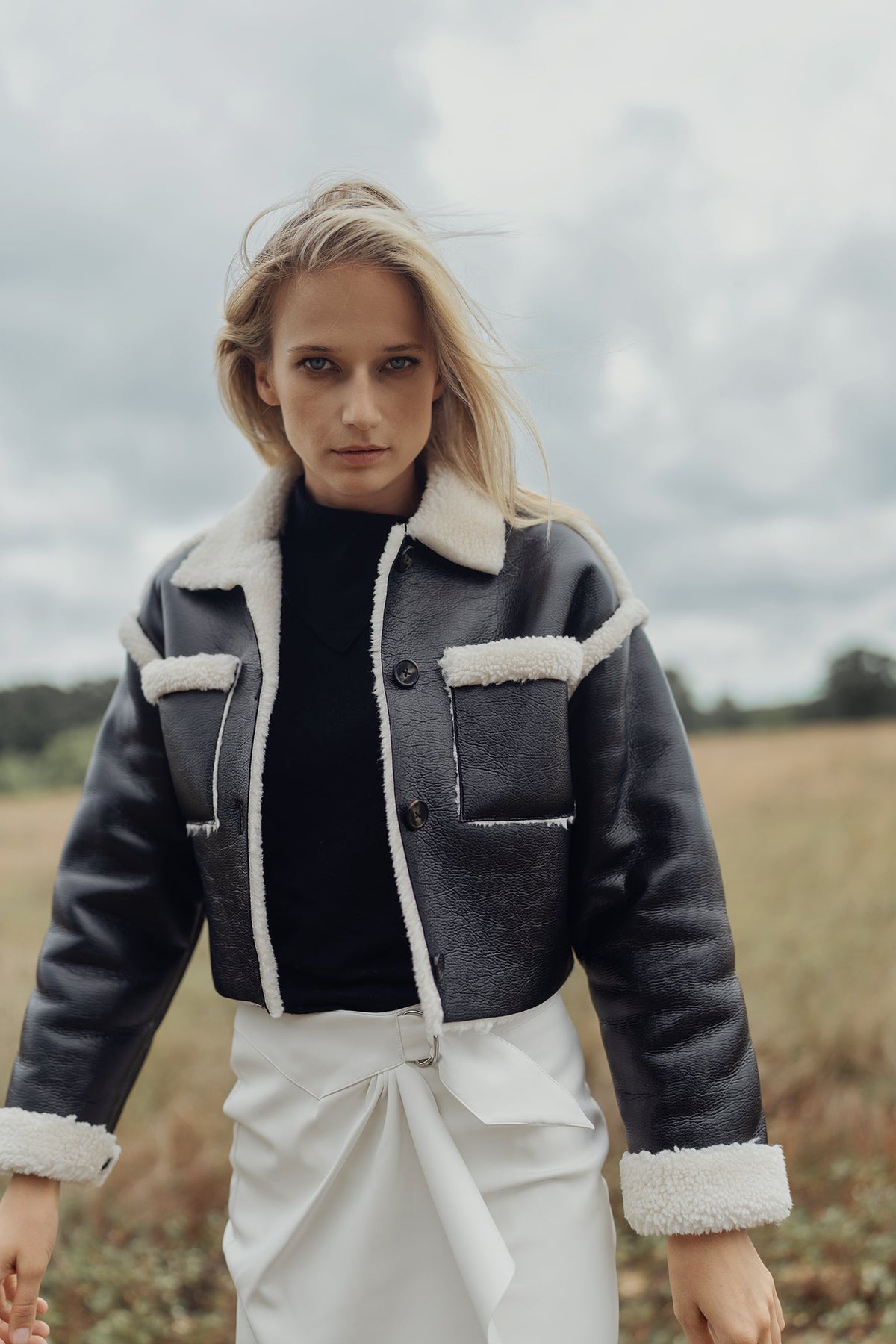 Navy leather sherpa jacket by Profile NYC featuring a cozy sherpa lining and stylish design, displayed on a hanger.