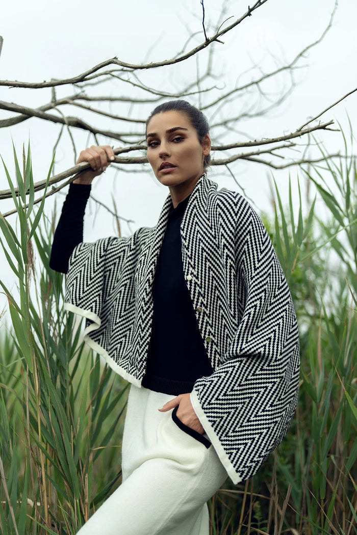 Soft knit shawl by profile-nyc, draped over a neutral background, showcasing its cozy texture and versatile style.