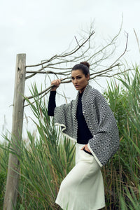 Soft knit shawl by Profile NYC draped over a neutral background, showcasing its cozy texture and versatile style.