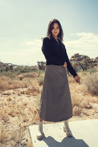 Wool seam skirt by Profile NYC featuring a fitted silhouette and seam details, styled in neutral tones.