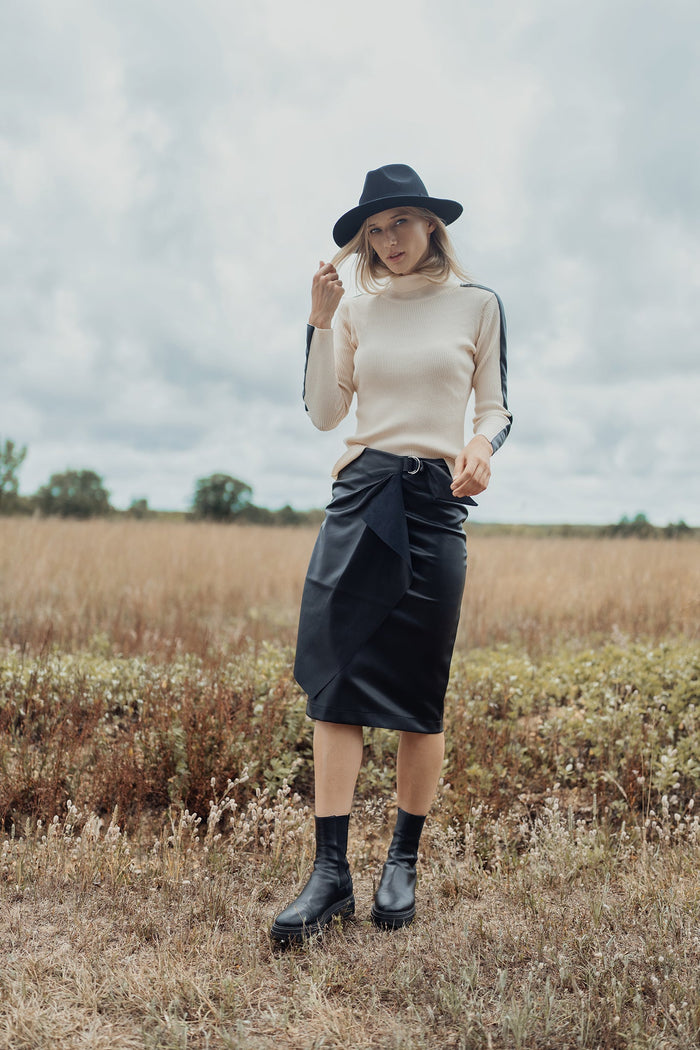 Black straight leather skirt with buckle detail by profile-nyc, shown on a model with a sleek, fitted silhouette.