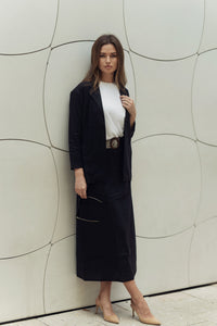 Ivory Lina belted skirt by profile-nyc, shown flat on a white background with a tie belt and clean, tailored design.