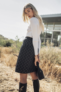 Quilted skirt by profile-nyc featuring a stylish, padded design and knee-length silhouette in a neutral color.