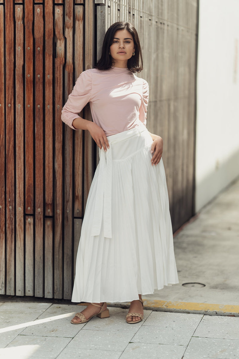 Pleated drop waist skirt by Profile NYC displayed on a model, featuring a flowy design and feminine silhouette.