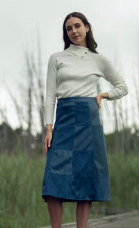 Black leather suede skirt from Profile NYC, shown on a model, featuring a stylish, fitted design with a high waist.