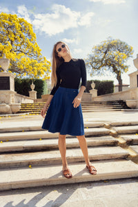Profile NYC panel pleated skirt shown in black with a high waist and flowing pleats, styled for a chic, sophisticated look.