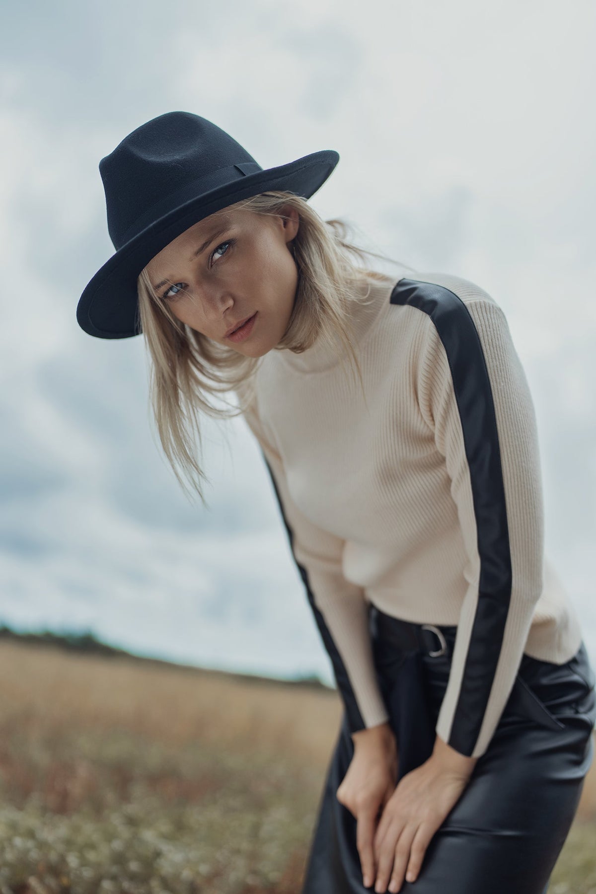Navy turtleneck sweater with leather shoulder detail from Profile NYC, featuring a cozy knit and stylish leather accents.