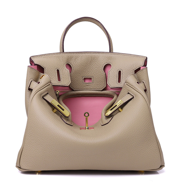 White women's leather handbag by Rirati, made from genuine cowhide, featuring a portable design and 35cm strap.