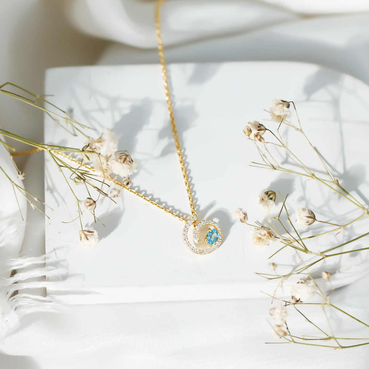 Genuine sky blue topaz and diamond swirl pendant necklace with silver chain from Rosec Jewels.
