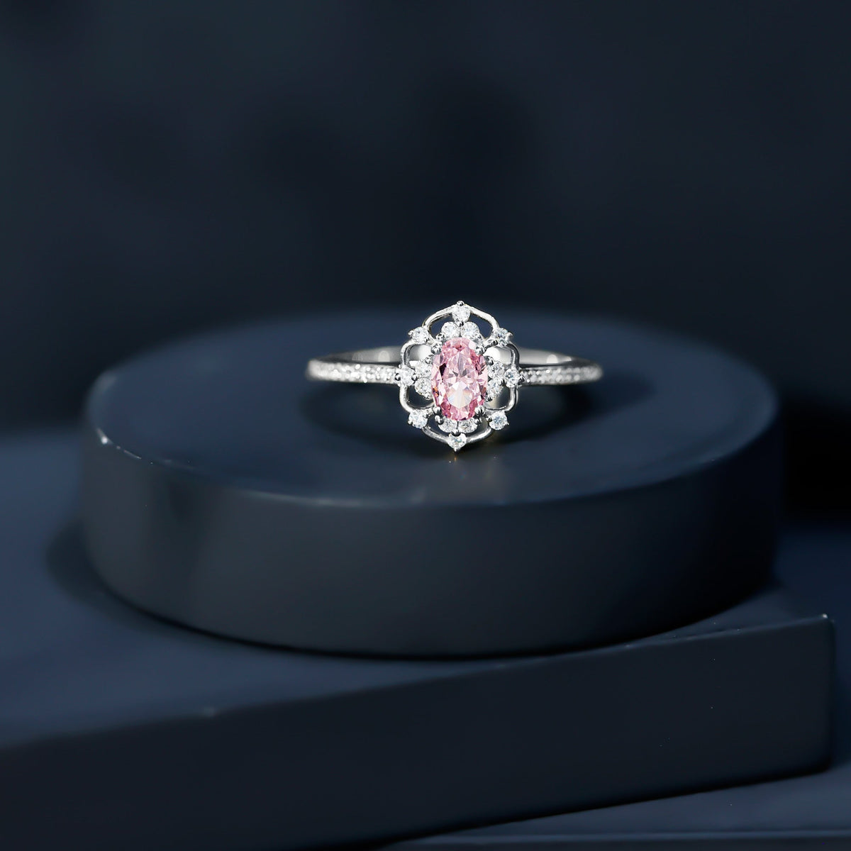 Natural pink sapphire and diamond vintage engagement ring in silver featuring intricate detailing and a elegant design.