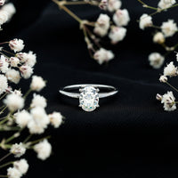 Oval moissanite solitaire engagement ring with 6x8mm stone, set in a rose gold band by Rosec Jewels.
