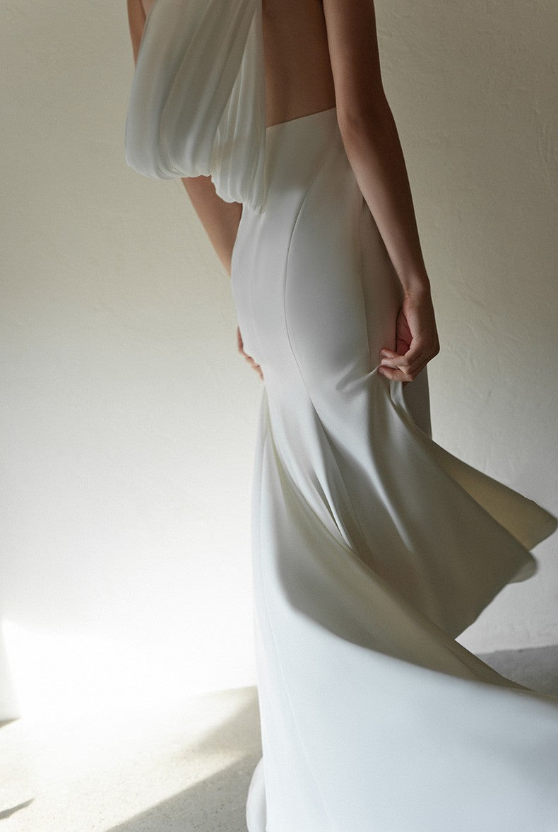 SelenaHuanStudio minimalist one-shoulder silky satin wedding dress with draped back, shown on a model.