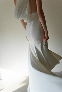 SelenaHuanStudio minimalist one-shoulder silky satin wedding dress with draped back, shown on a model.