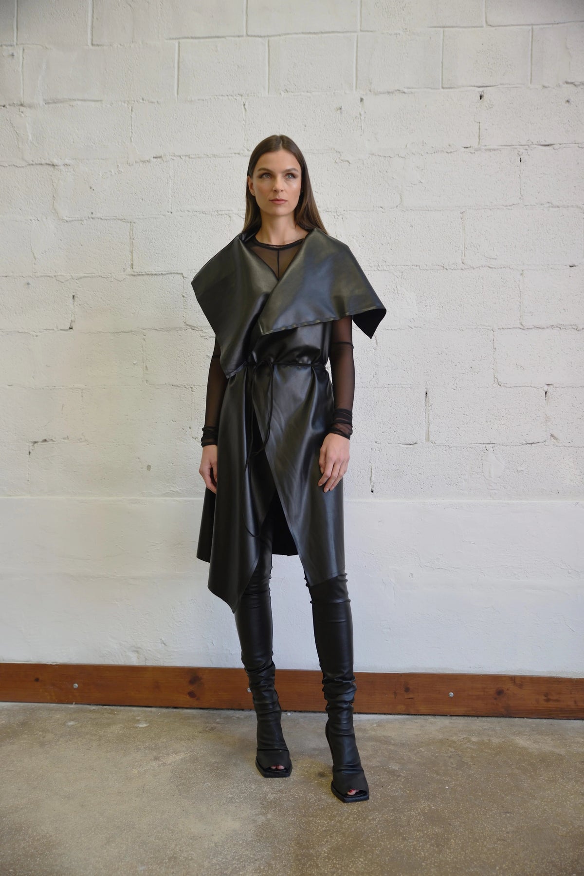 Uneven sleeveless coat by SIMPLY MILA, modern women's fashion, featuring a stylish asymmetrical design and neutral fabric.