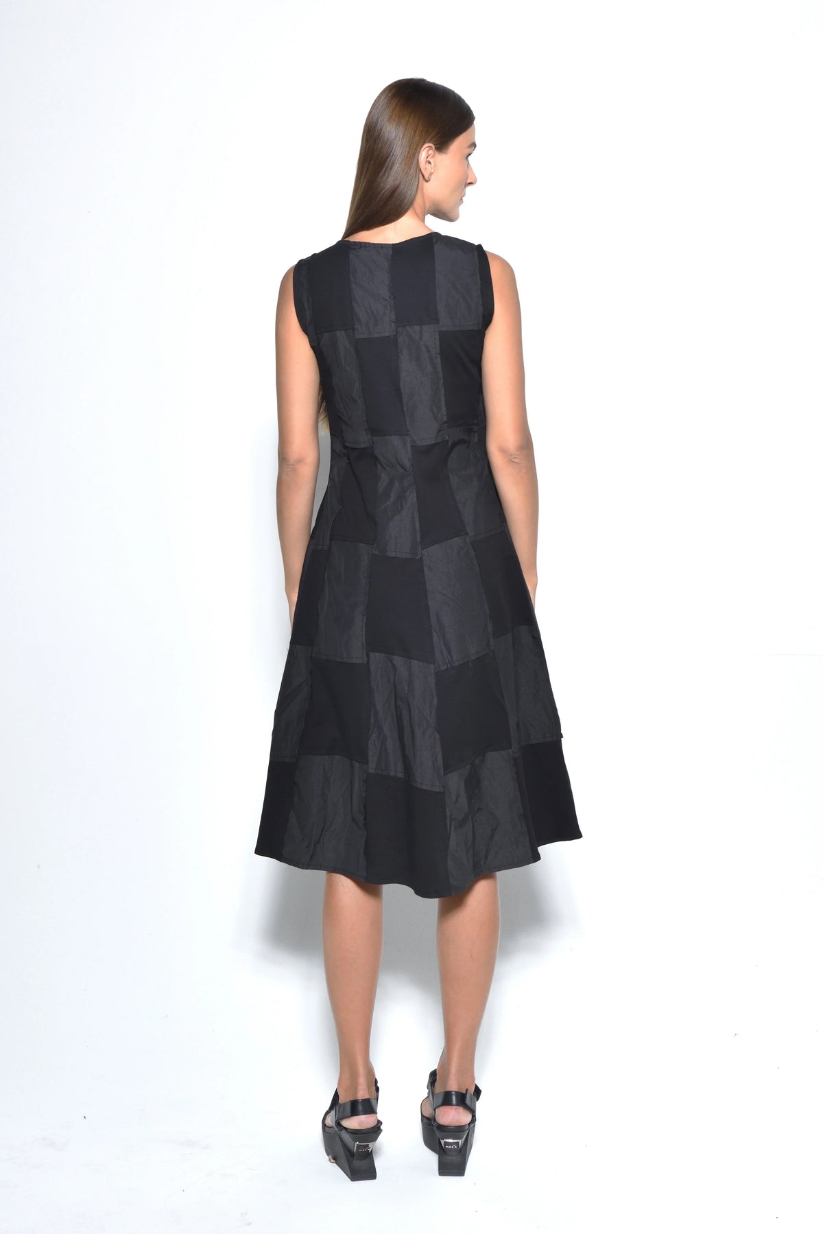 Back view of a sleeveless chessboard dress from SIMPLY MILA Modern Women's Clothing, featuring a stylish black and white checkered pattern.