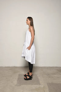 White linen peplum dress by SIMPLY MILA, side view showcasing fitted waist and flowing skirt for modern women's fashion.